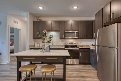 A kitchen with a stainless steel refrigerator and a white countertop.
