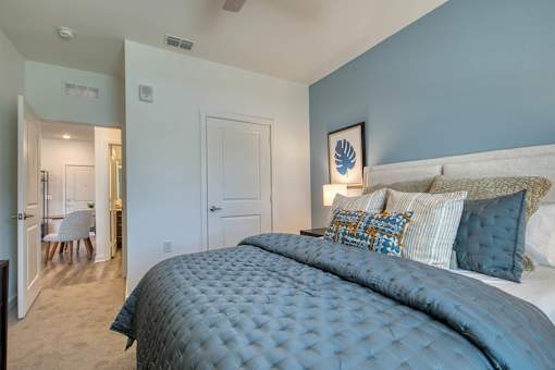 A bedroom with a large bed and a ceiling fan.