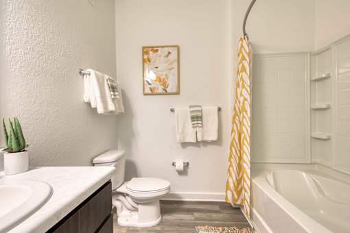 A bathroom with a toilet, sink, and a shower curtain.
