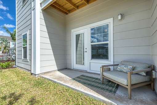 A house with a white door and a bench outside.