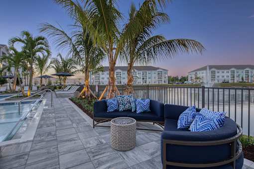 A patio with a couch and a pool.