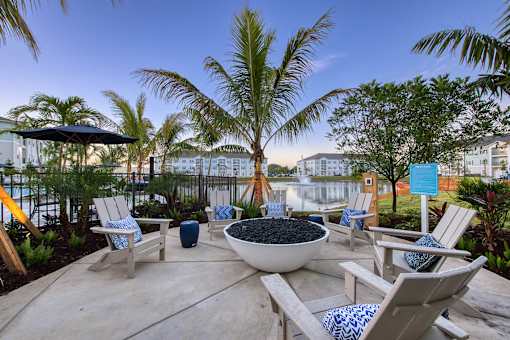 A patio with chairs and a bowl of fruit.