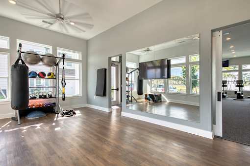 A room with a punching bag, mirrors, and a television.