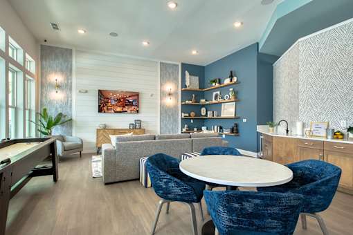 A modern living room with a dining table and blue chairs.