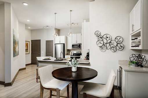 A modern kitchen with a dining table and chairs.
