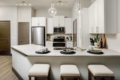A modern kitchen with a large island and stools.