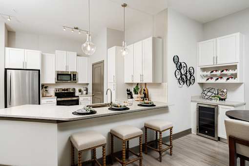 A modern kitchen with white cabinets and a large island.