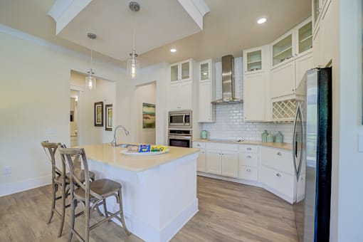 A kitchen with a white island and wooden floors.
