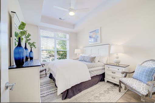 A bedroom with two beds, a dresser, and a chair.