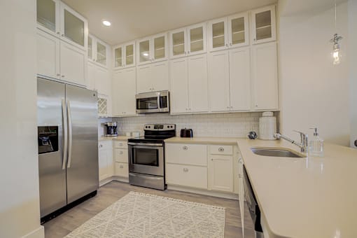 A kitchen with white cabinets and appliances.