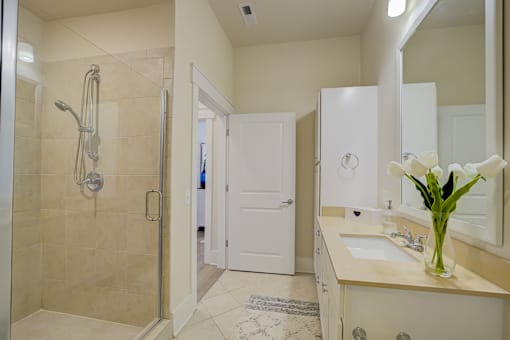 A bathroom with a white sink and a white shower.