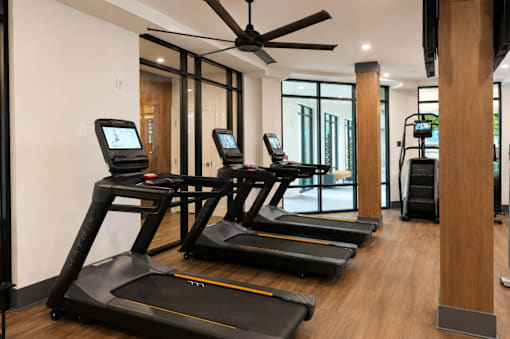 A gym with treadmills and a ceiling fan.