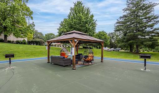 A gazebo with a basketball court in front of it.