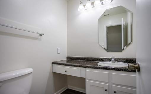 A bathroom with a white tub, sink, and mirror.