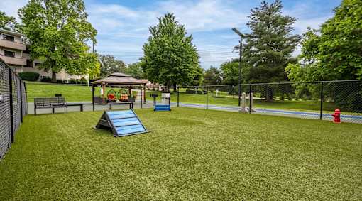 A playground with a slide, a swing set, and a fire hydrant.