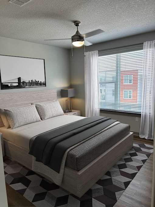 A bedroom with a large bed and a painting of a bridge on the wall.