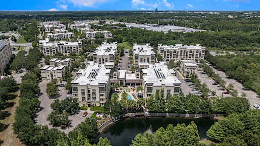 A bird's eye view of a residential complex with a lake in the foreground.