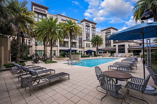 A pool area with sun loungers and a table.