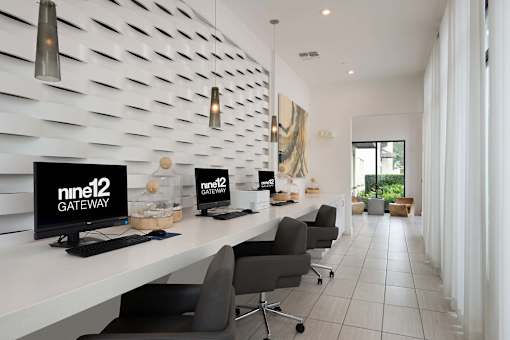 A modern office space with white desks and black chairs.