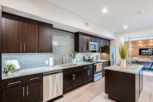 A modern kitchen with dark wood cabinets and a granite countertop.