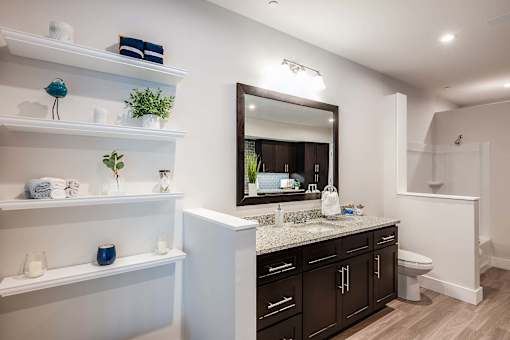A bathroom with a white counter and a mirror.