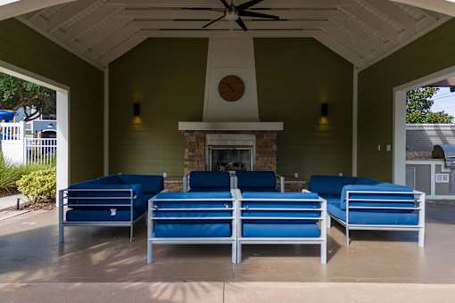 A patio with a fireplace and blue couches.