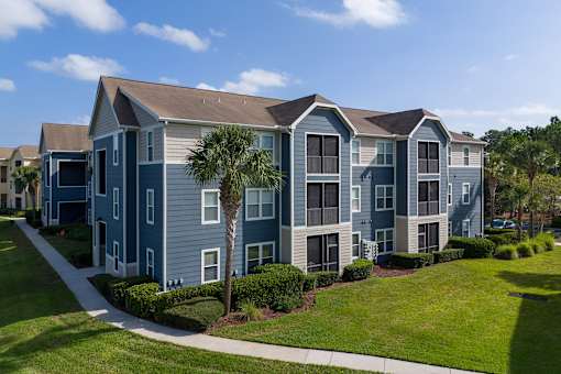 A row of townhouses with a tree in front of the first one.