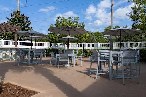 A patio with tables and chairs under umbrellas.