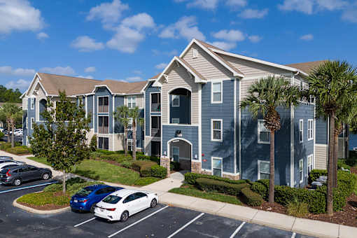 A car is parked in a parking lot in front of a building.