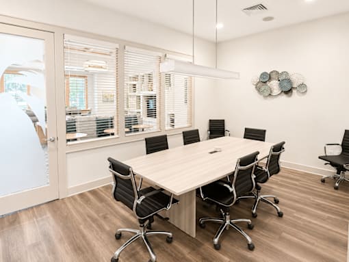 A conference room with a long table and chairs.