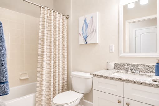 A white toilet sits next to a bathtub in a bathroom.
