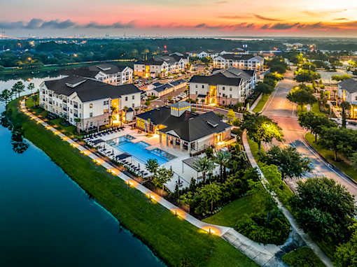 A resort with a swimming pool and a body of water in front.
