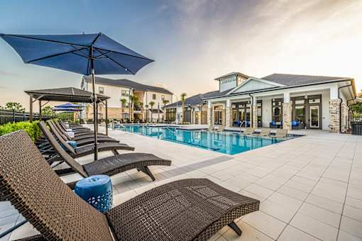 A poolside area with lounge chairs and umbrellas.