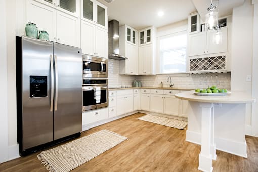 A kitchen with a refrigerator, microwave, and oven.