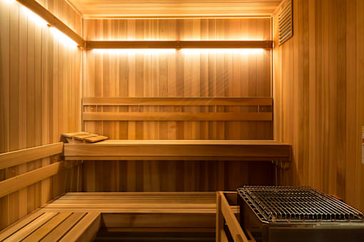 A wooden sauna with a bench and a heater.
