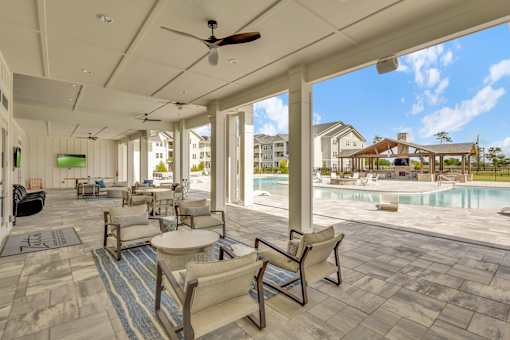 A patio with a pool and chairs.
