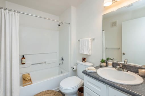 A white bathroom with a toilet, sink, and bathtub.