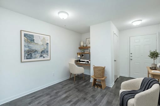 A room with a painting on the wall and a chair with a blanket on it.