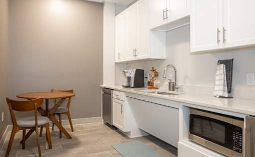 A kitchen with a table and chairs.