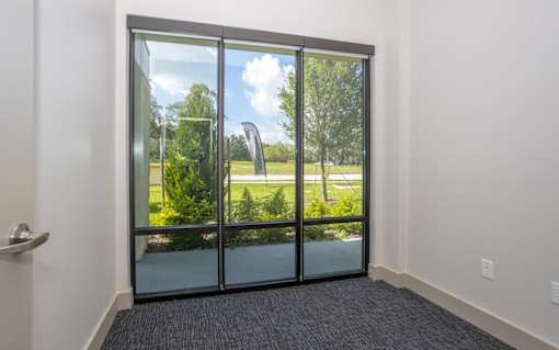 A room with a glass door leading to a green outdoor area.