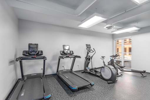 A gym with treadmills, exercise bikes, and elliptical machines.