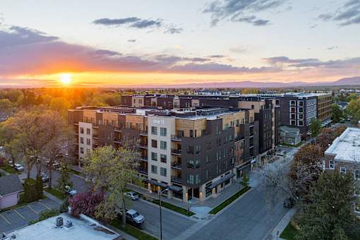 A sunset view of a residential area with apartment buildings.