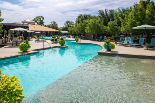 a resort style pool with lounge chairs and umbrellas at Orion McCord Park, Little Elm, TX, 75068