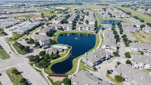 A bird's eye view of a residential area with a large lake in the middle.