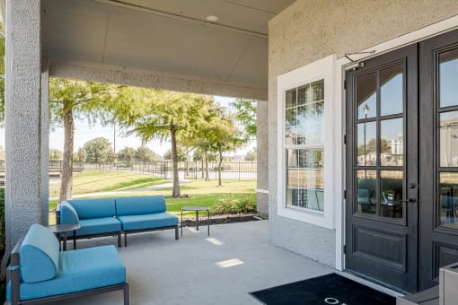 a patio with blue couches and chairs and a door at Orion Prosper, Prosper, TX, 75078