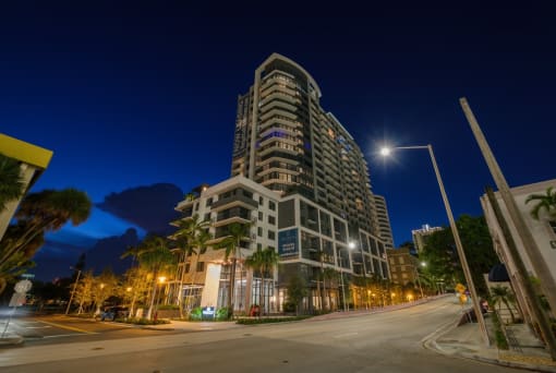 a city street at night with a tall building in the background at Regatta at New River, Fort Lauderdale Florida