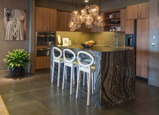 a kitchen with a center island and three stools at Regatta at New River, Fort Lauderdale, FL