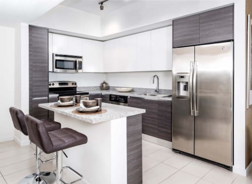 a kitchen with white cabinets and stainless steel appliances at Regatta at New River, Fort Lauderdale Florida