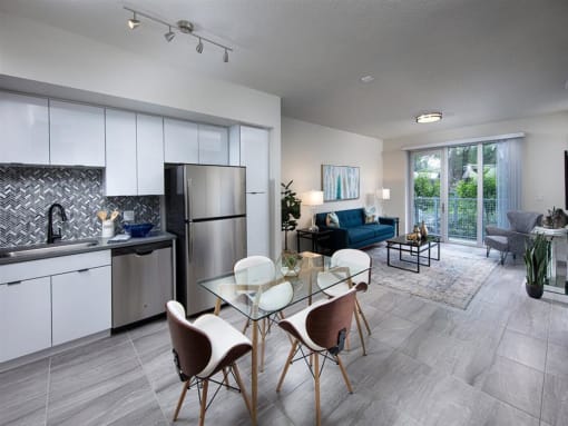 a kitchen and living room with white cabinets and stainless steel appliances at Saba Pompano Beach, Pompano Beach, 33062