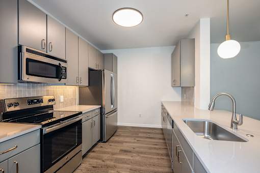 A kitchen with a stove top oven, microwave, and refrigerator.